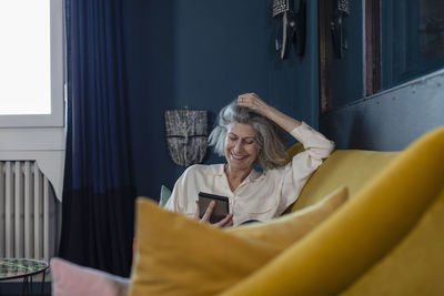 Young woman using mobile phone at home