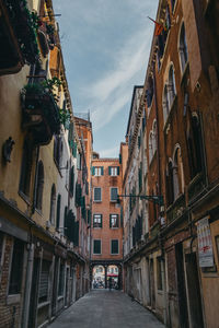 Narrow street amidst buildings in city against sky