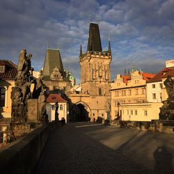 Charles bridge by st vitus cathedral against sky