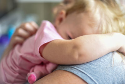 Midsection of woman embracing daughter at home