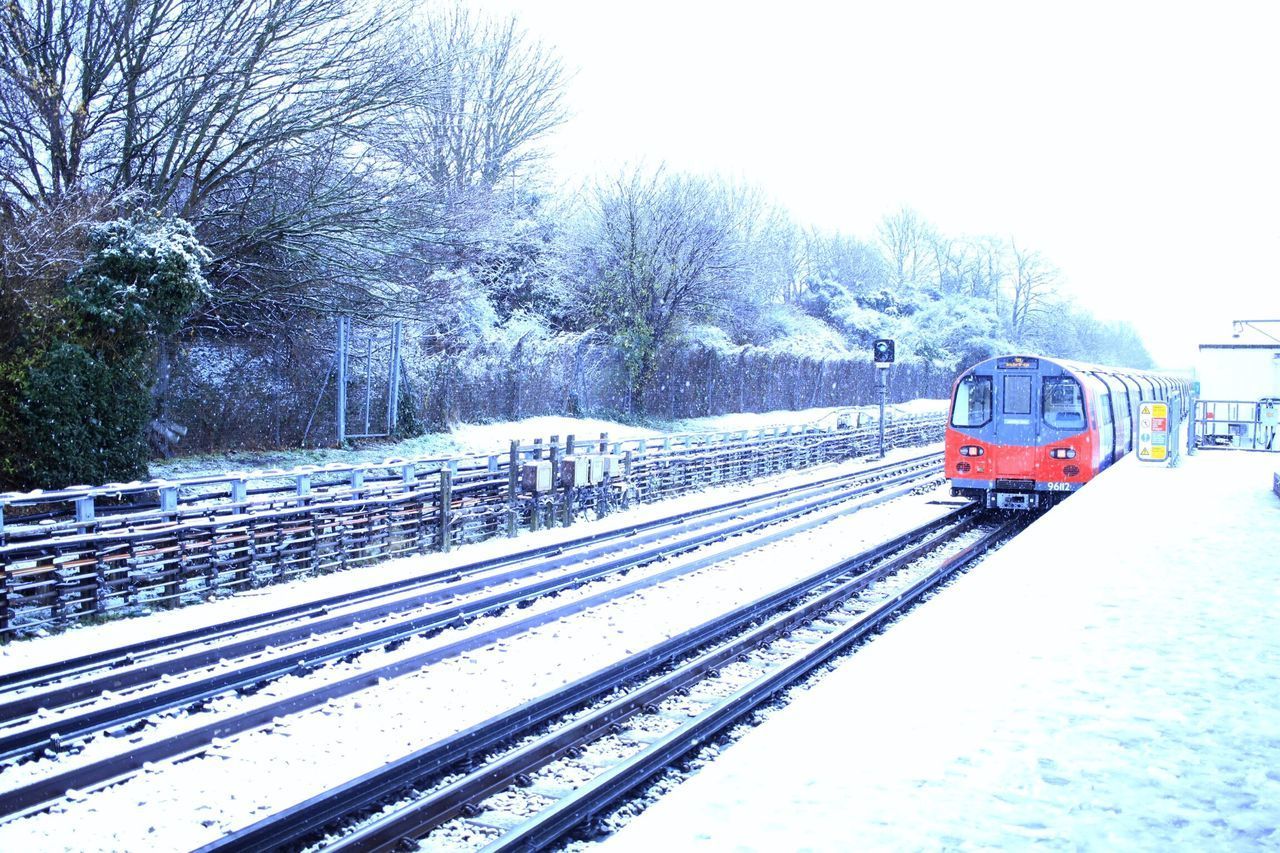 TRAIN ON RAILROAD TRACK AGAINST CLEAR SKY