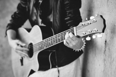 Midsection of man playing guitar