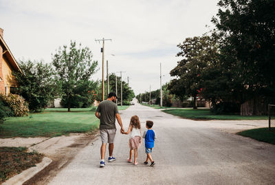 Rear view of father with daughter against plants