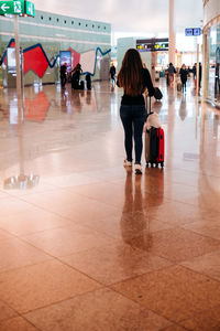 Rear view of people walking on tiled floor