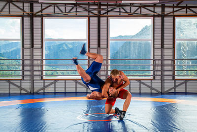 Greco-roman wrestling training, grappling. two greco-roman wrestlers in red and blue uniform making 