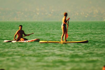 Rear view of men on boat in sea