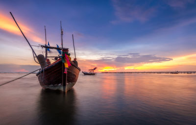 Sailboat in sea against sky during sunset