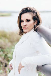 Portrait of young woman leaning on railing