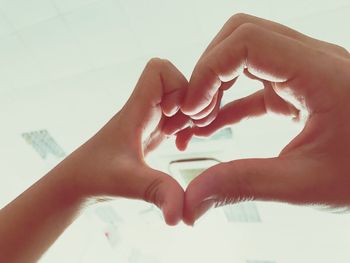 Cropped image of people making heart shape with hands