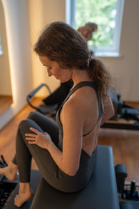 Side view of woman exercising in gym