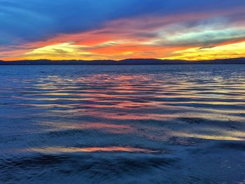 Scenic view of sea against dramatic sky during sunset