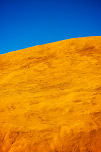 Scenic view of desert against clear blue sky