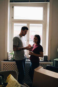 Man showing mobile phone to woman at home