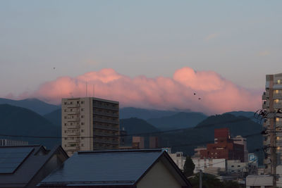 Buildings in city against sky during sunset