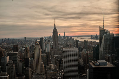 Modern buildings in city against cloudy sky