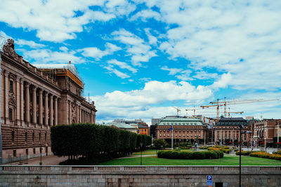 Buildings in city against cloudy sky
