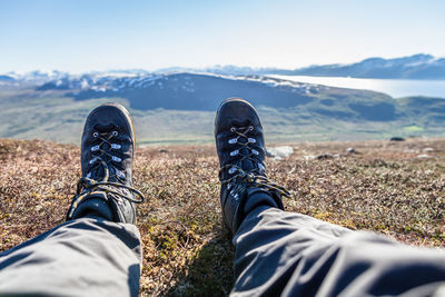 Low section of man relaxing on mountain