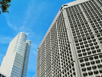 Low angle view of modern buildings against blue sky