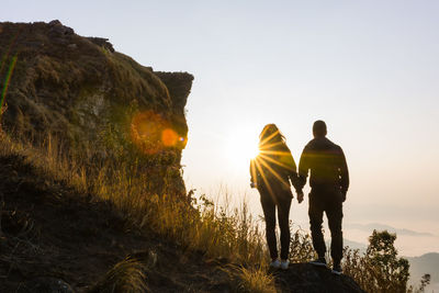 Rear view of people walking on rock