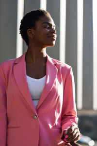 Smiling businesswoman looking away while standing in balcony