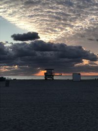 Scenic view of beach against sky at sunset