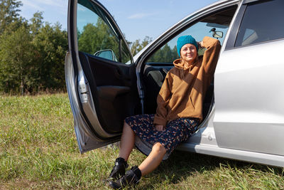 Fashion lifestyle portrait of young trendy woman dressed in beige sweatshirt, blue knitted hat