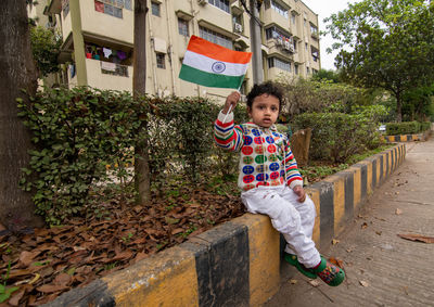Portrait of boy standing on footpath