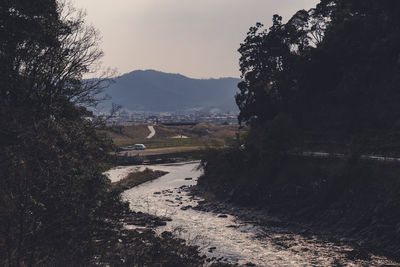 Scenic view of road by mountains against sky