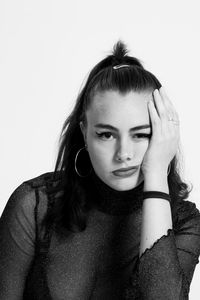 Portrait of young woman against white background