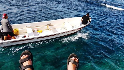 Low section of men on boat in sea