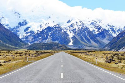 Road amidst snowcapped mountains against sky