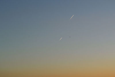 Low angle view of birds flying against clear sky