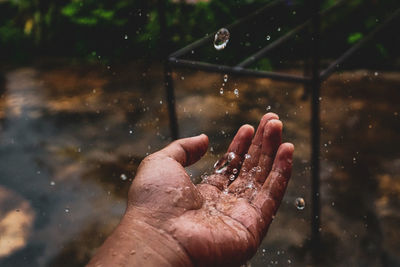 Close-up of hand catching water during rainy season