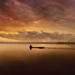 Silhouette boat in sea against sky during sunset