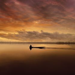 Silhouette boat in sea against sky during sunset