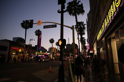 Road sign on city street against sky