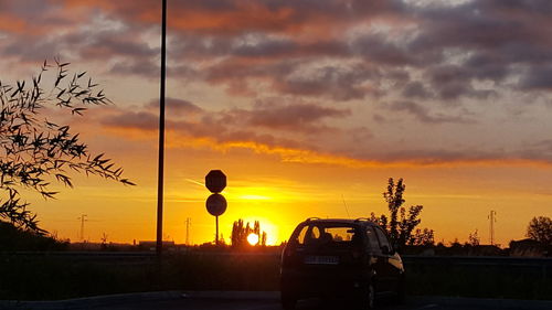 Silhouette car against sky during sunset