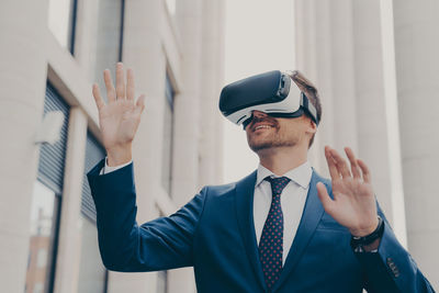 Side view of businessman wearing sunglasses while standing in city