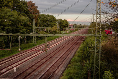 Railroad tracks by trees against sky