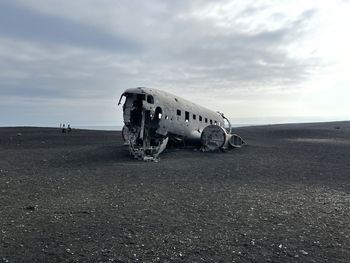 Abandoned airplane on airport runway against sky