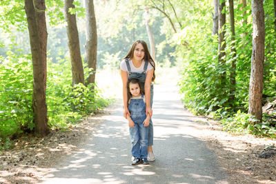 Full length portrait of a smiling girl in forest