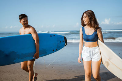 Portrait of young woman standing at beach