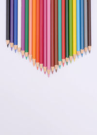 Multi colored pencils against white background