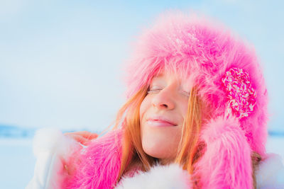 Portrait of beautiful woman against pink sky