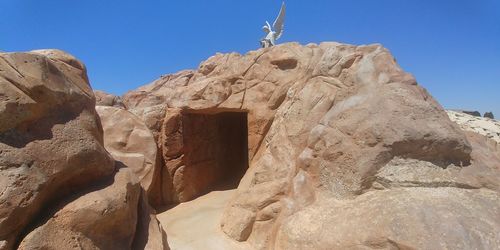 Low angle view of rocks against clear sky