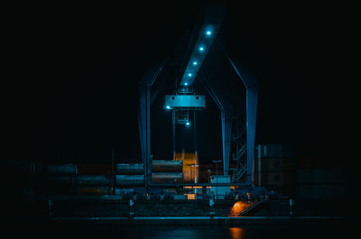 Illuminated factory against sky at night