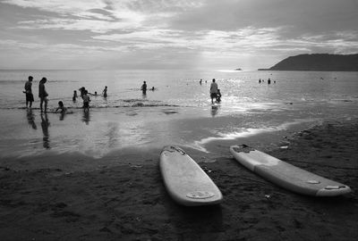 People at beach against sky