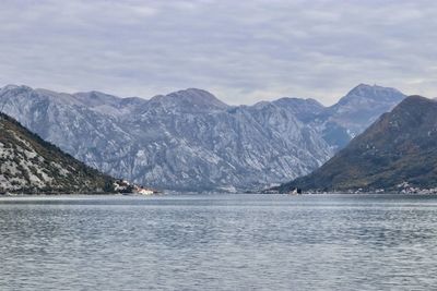 Scenic view of lake by mountains against sky