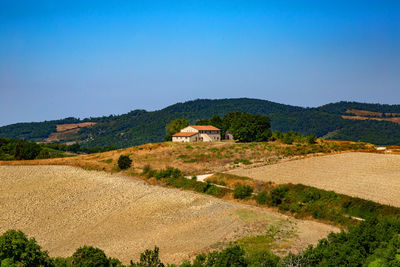 Scenic view of field by mountains against sky