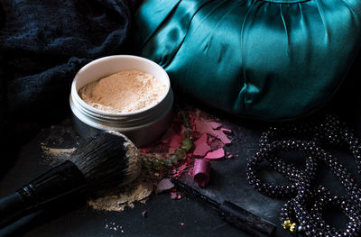 High angle view of beauty products by necklace on table